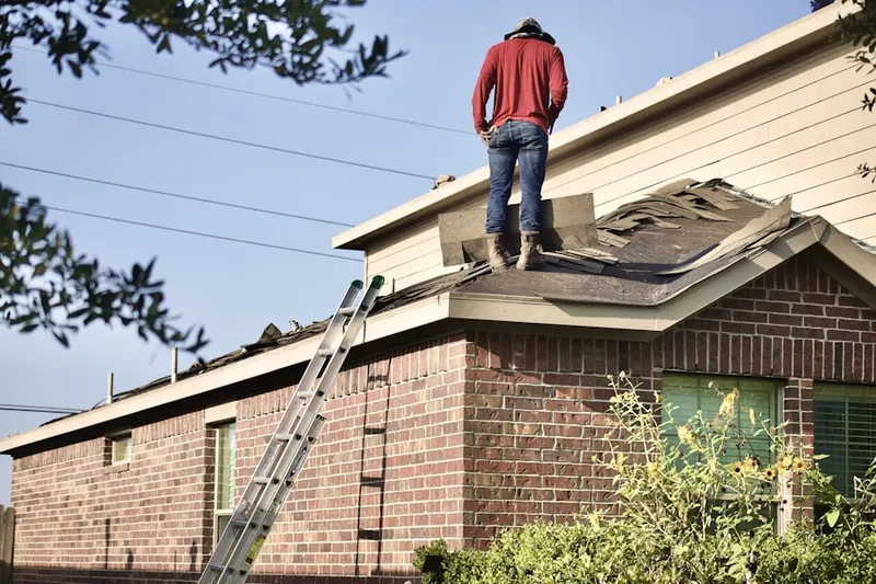 Professional roofer working on a residential roof in Keene Mill Manor